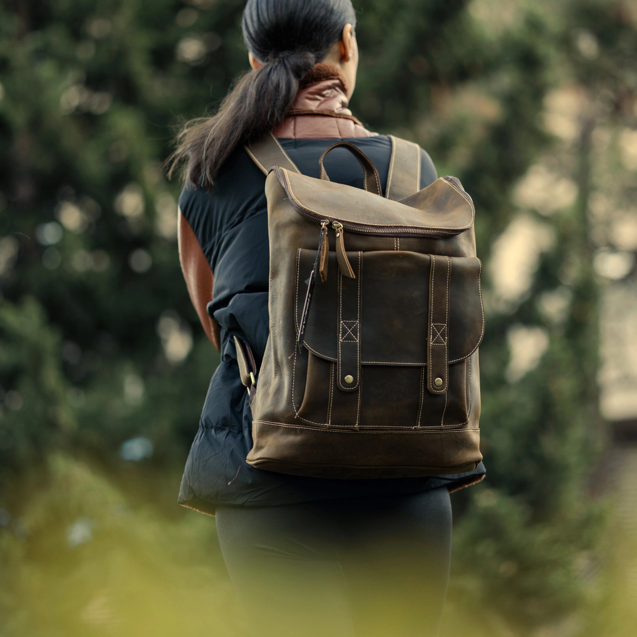 model wearing cognac brown leather backpack